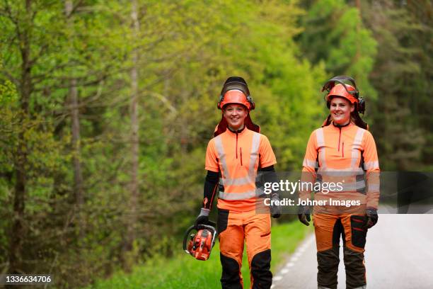 female lumberjacks walking on forest road - forestry industry stock pictures, royalty-free photos & images