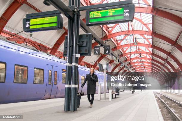 man checking timetable at train station - departure board front on fotografías e imágenes de stock