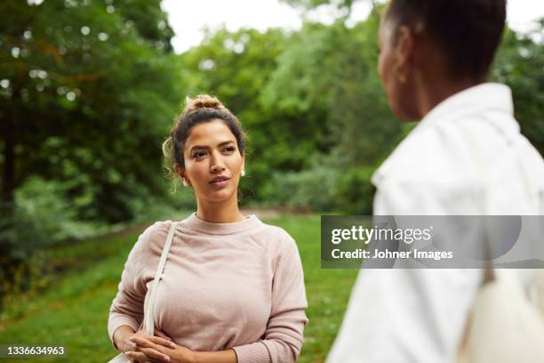 women talking in park - two women talking stock pictures, royalty-free photos & images