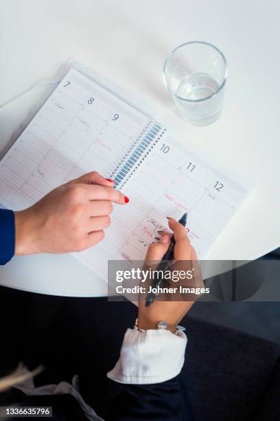 woman's hands doing notes in diary - almanac publication stockfoto's en -beelden