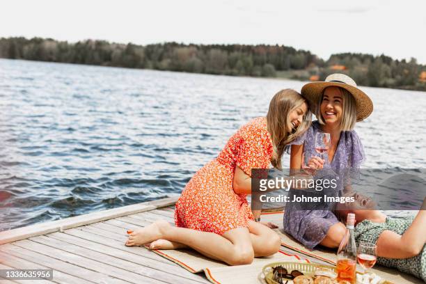 female friends having picnic on jetty - standing water stock pictures, royalty-free photos & images