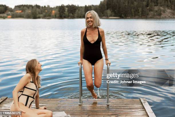 happy female friends at lake - bathing jetty stock pictures, royalty-free photos & images