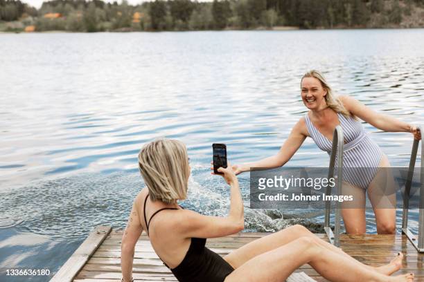 happy female friends at lake - bathing jetty stock pictures, royalty-free photos & images