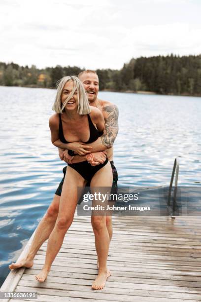 happy couple standing on jetty - bathing jetty stock pictures, royalty-free photos & images