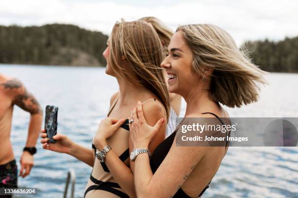 happy female friends at lake - bathing jetty stock pictures, royalty-free photos & images