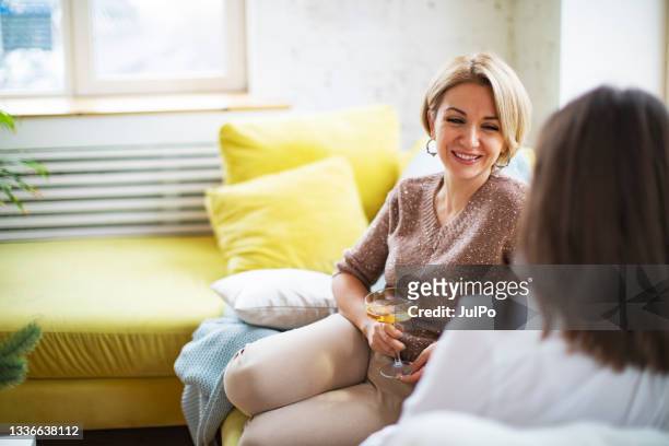two woman sitting with wine and talking at home - beautiful armenian women stock pictures, royalty-free photos & images