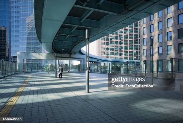 businessman walking in modern business district - tokyo financial district stock pictures, royalty-free photos & images