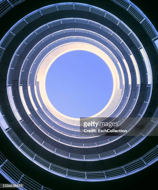 morning sunlight entering spiral roadway of a parking garage - architecture stock pictures, royalty-free photos & images