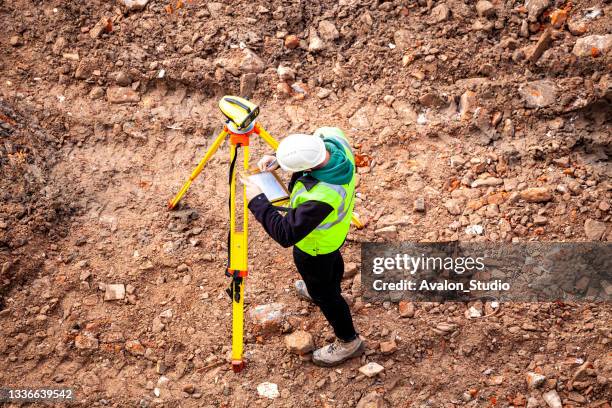 un geometra in un cantiere utilizza un livello ottico - geometra foto e immagini stock