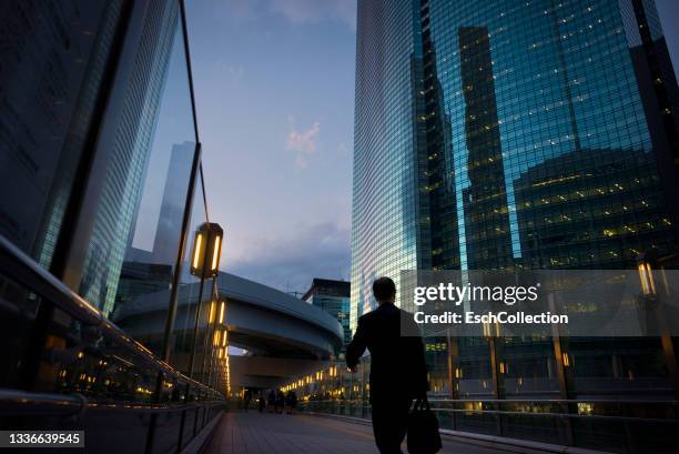 businessman walking at shiodome business district in tokyo, japan - emperor go kashiwabara of japan stockfoto's en -beelden