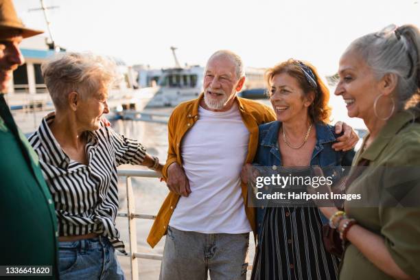 group of happy senior friends tourists standing in city port, talking. - 60 65 man fotografías e imágenes de stock