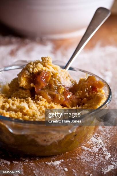 traditional rhubarb crumble in a glass dish in a home kitchen setting - cobbler stock pictures, royalty-free photos & images