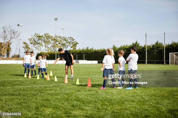 soccer coach training kids in field - sports training drill 個照片及圖片檔