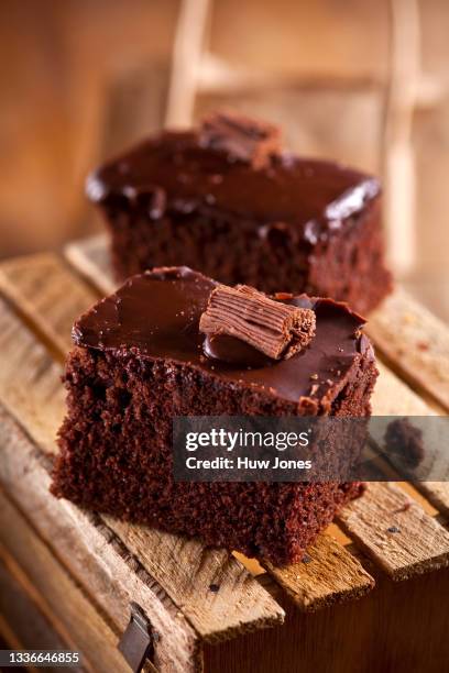two slices of chocolate cake on a wooden tabletop - brownie stock pictures, royalty-free photos & images