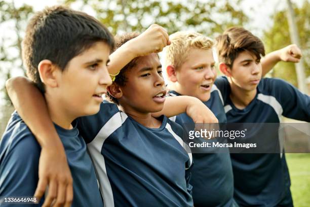 happy teenage boys cheering in soccer ground - boy soccer team stock pictures, royalty-free photos & images