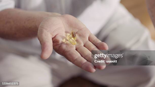 senior man taking food supplements and vitamins capsules - omega 3 stock pictures, royalty-free photos & images