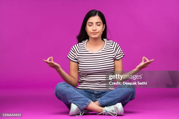 young woman on purple background - fashion woman floor cross legged stock pictures, royalty-free photos & images