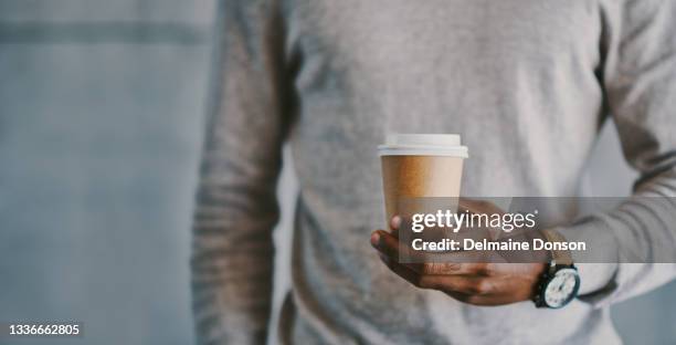 shot of a businessman holding a cup of coffee - coffe to go stockfoto's en -beelden