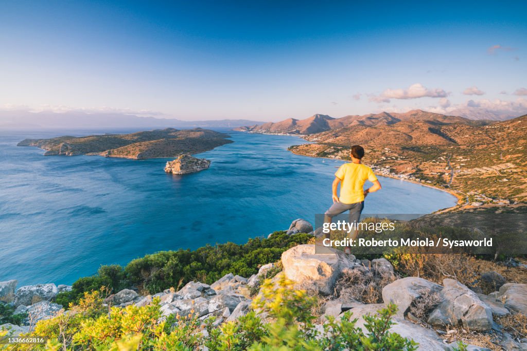 One man enjoying sunrise over blue sea, Crete, Greece