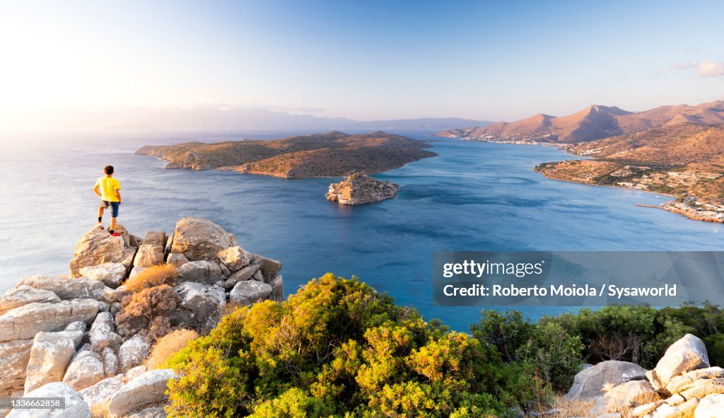 Man watching Spinalonga island at dawn, Crete, Greece