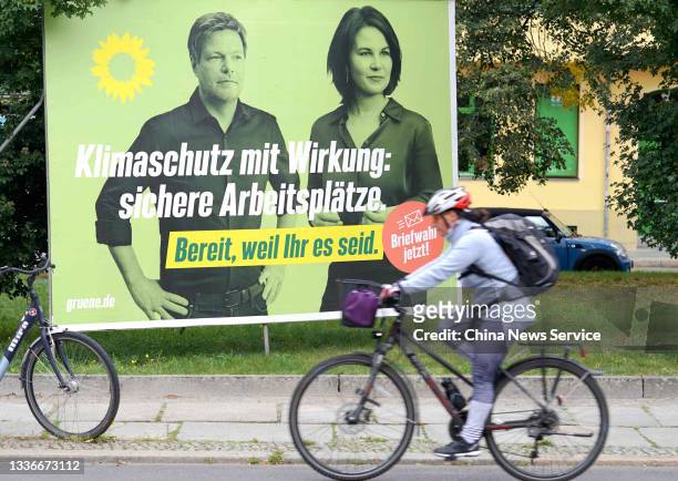 Cyclist rides past an election campaign billboard showing Robert Habeck and chancellor candidate Annalena Baerbock of the German Greens Party, on...