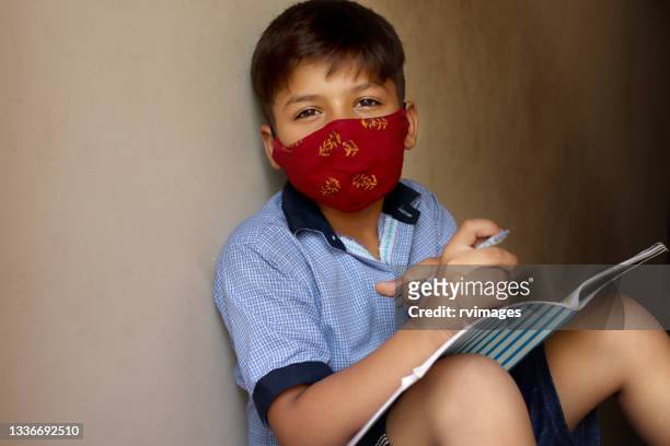 8-9 years schoolboy studying at home during covid-19, lockdown period. - 8 9 years stock pictures, royalty-free photos & images