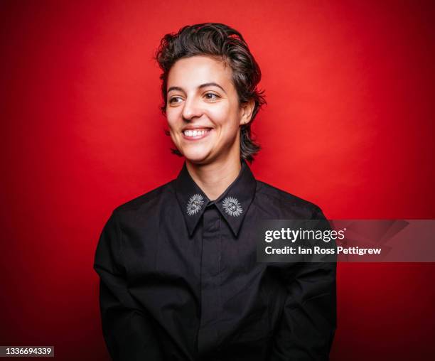 androgynous woman, black shirt on red background - portrait fond rouge photos et images de collection