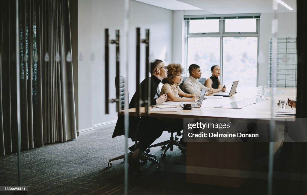 Aufnahme einer Gruppe von Geschäftsleuten, die sich bei der Arbeit in einem Sitzungssaal treffen