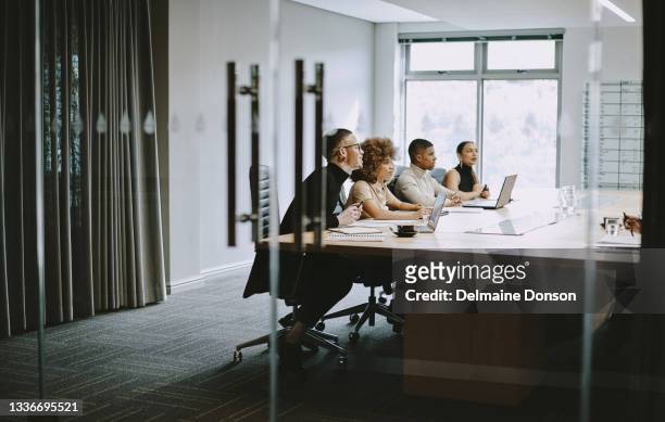 aufnahme einer gruppe von geschäftsleuten, die sich bei der arbeit in einem sitzungssaal treffen - board room stock-fotos und bilder