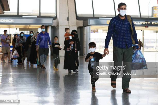 Refugees arrive at Dulles International Airport after being evacuated from Kabul following the Taliban takeover of Afghanistan August 27, 2021 in...
