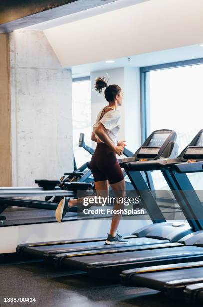 ジムでトレッドミルで走る匿名のスポーツウーマン - トレッドミル　女性 ストックフォトと画像