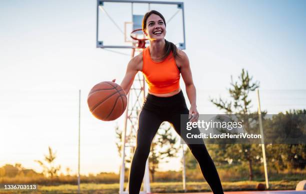 woman bouncing the ball in a street basketball court - saltar para cima e para baixo imagens e fotografias de stock