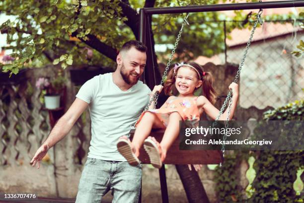 father enjoying quality time with female child on playground swing - using a swing stock pictures, royalty-free photos & images