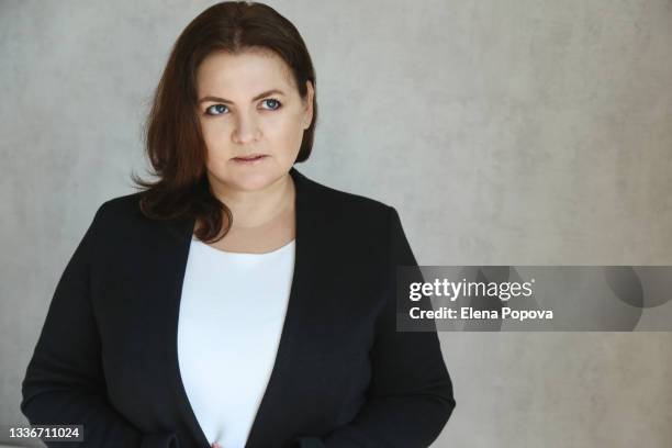 portrait of young adult business woman against grey wall background - white jacket stock pictures, royalty-free photos & images