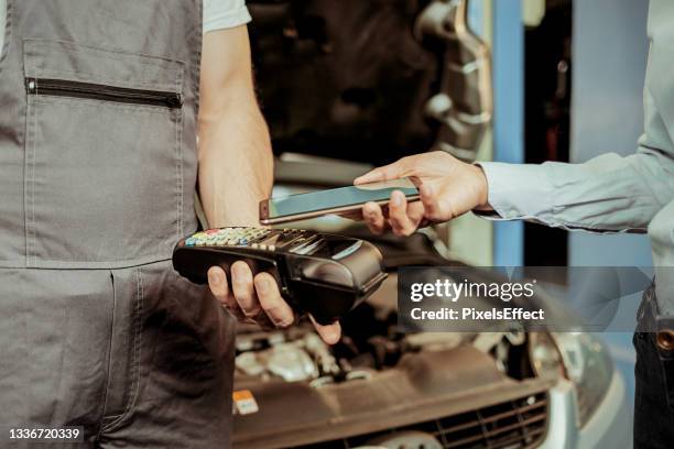 paying with smartphone - reparatiewerkplaats stockfoto's en -beelden