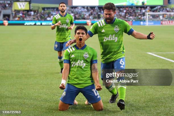 Fredy Montero of Seattle Sounders celebrates with Joao Paulo after scoring his second goal to add to the 2-0 lead against the Portland Timbers in the...