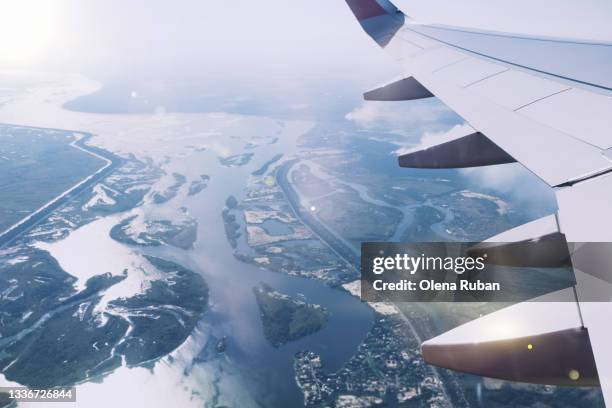 airplane wing in the window and long river - hublot photos et images de collection