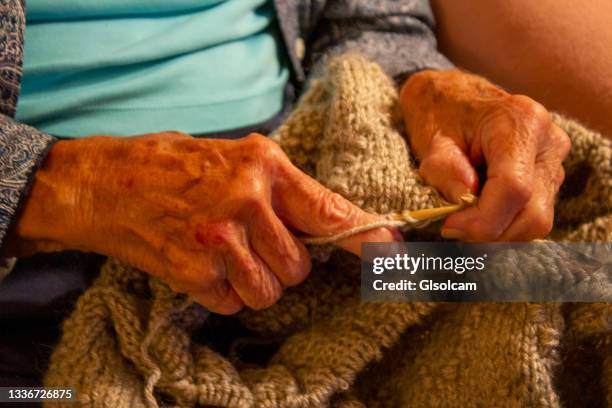 hands with rheumatoid arthritis knitting close-up - rheuma stock-fotos und bilder