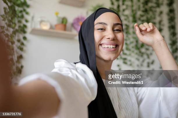 happy female professional taking selfie at home - arab face stock-fotos und bilder