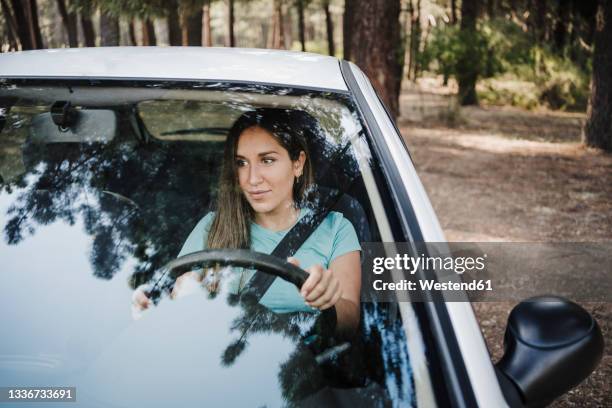 young woman driving car seen through glass window - front view of car stock pictures, royalty-free photos & images