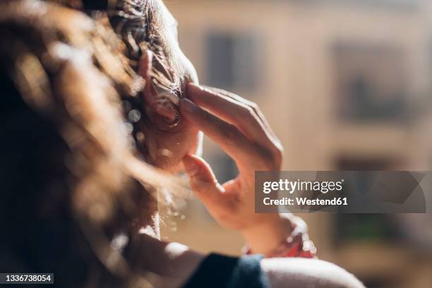 woman listening music through wireless in-ear headphones - in ear headphones photos et images de collection