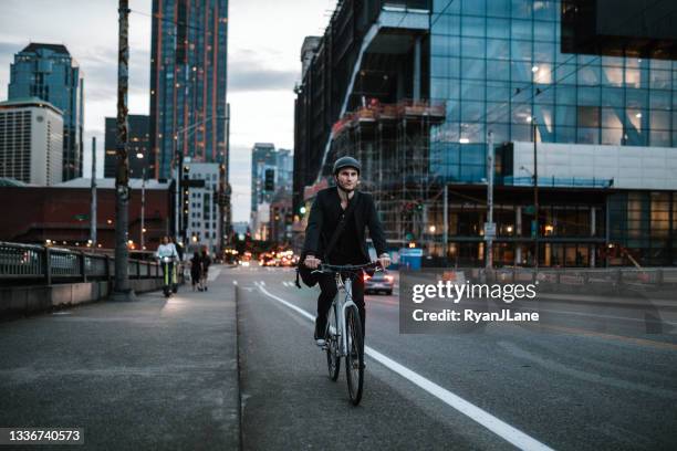 bike riding urban commuter at dusk - seattle city life stock pictures, royalty-free photos & images