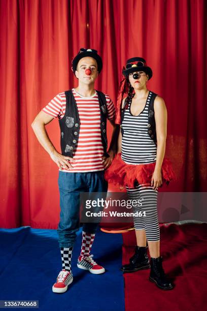 male and female acrobats wearing circus costumes standing on stage - clownsneus stockfoto's en -beelden
