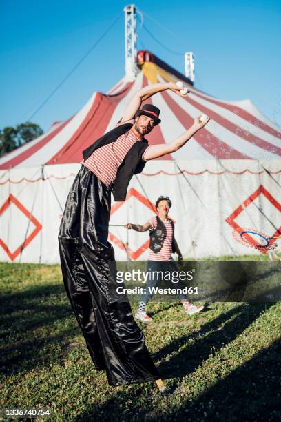 male artists performing together in front of circus tent - stilt stock pictures, royalty-free photos & images