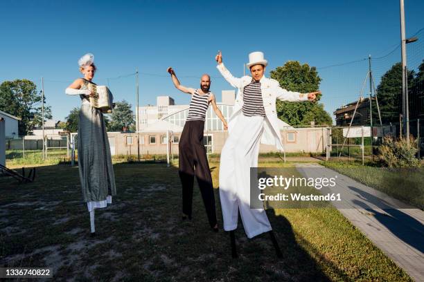 male and female artists dancing while standing on stilts - styltor bildbanksfoton och bilder