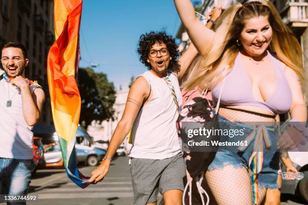 happy male and female activists walking on street - protest foto e immagini stock