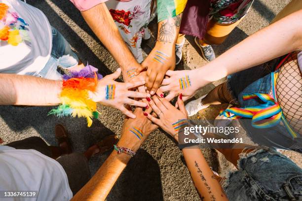 male and female activists with hands clasped on street - igualdad fotografías e imágenes de stock