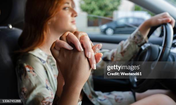 woman holding hand of female friend while driving car - car point of view stock pictures, royalty-free photos & images