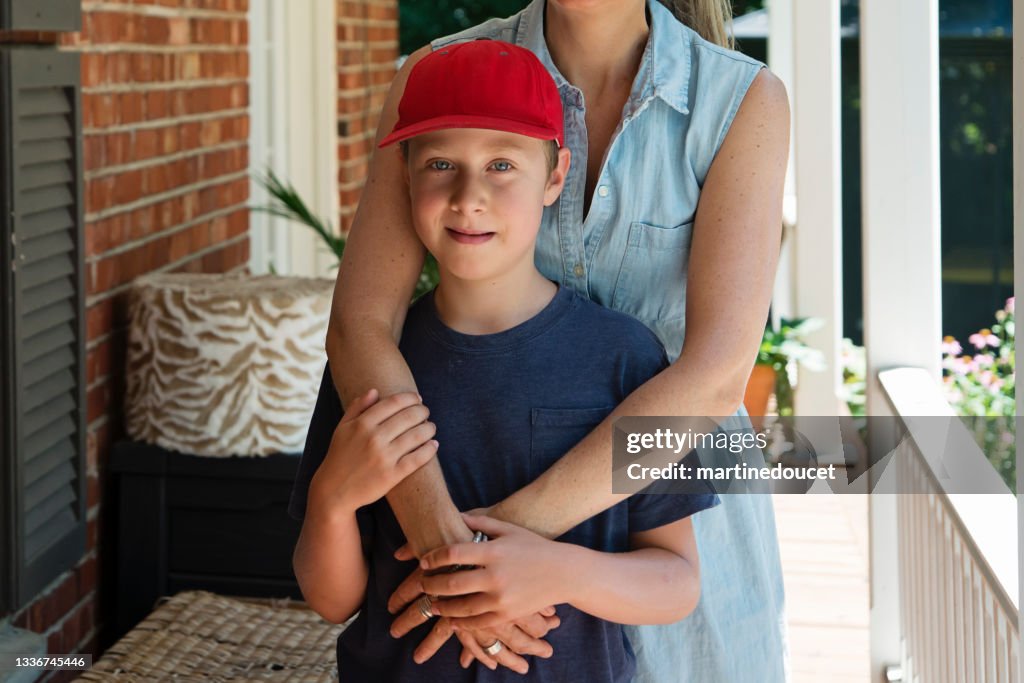 Mother comforting son on home porch.