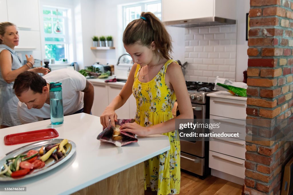 Família preparando almoço com envoltório de comida ecológica.